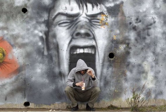 Un hombre bebe café apoyado en un mural en Mesenia (Peloponeso) en una foto tomada el 23 de marzo de 2012. 